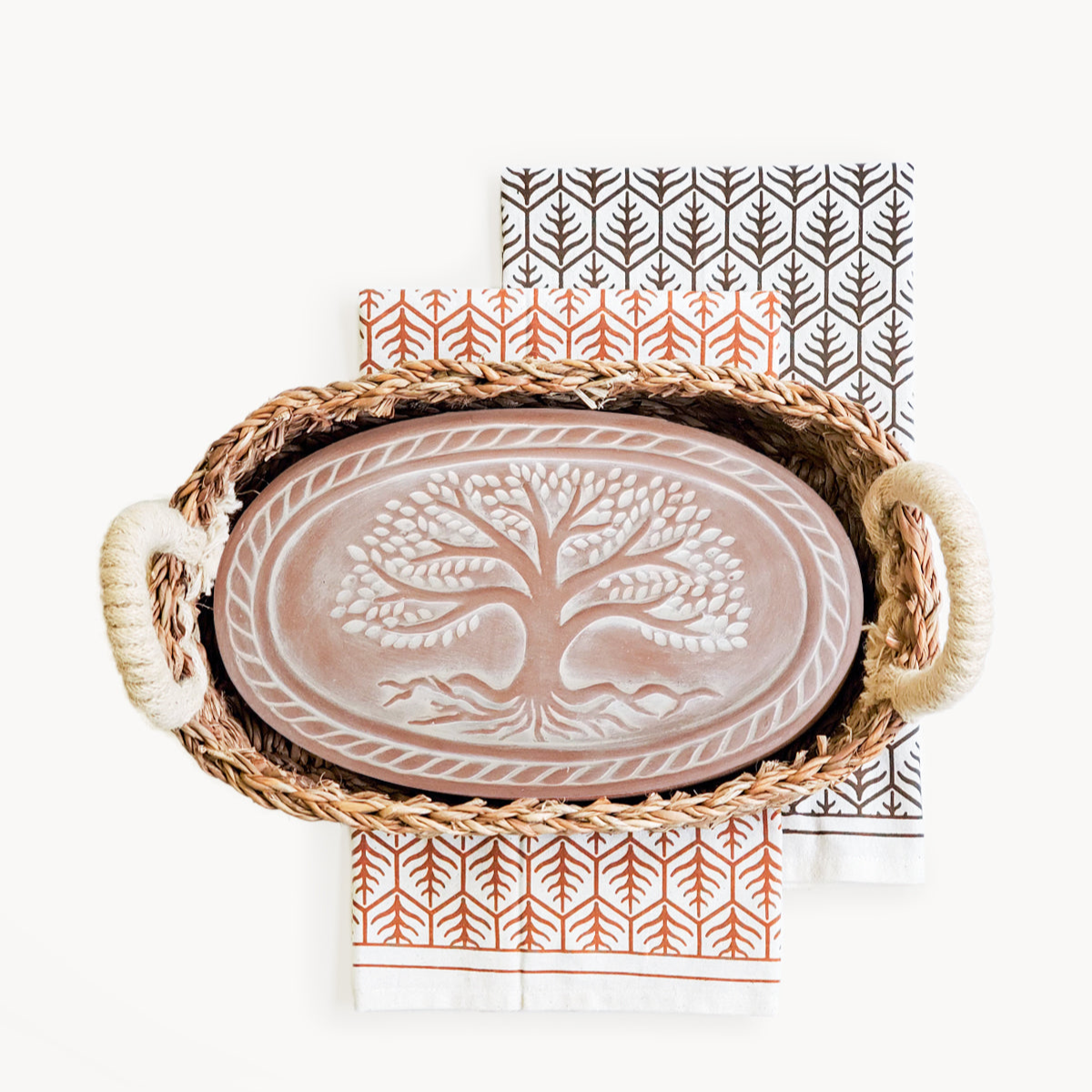 Ceramic tray with tree design in a woven basket on a white background