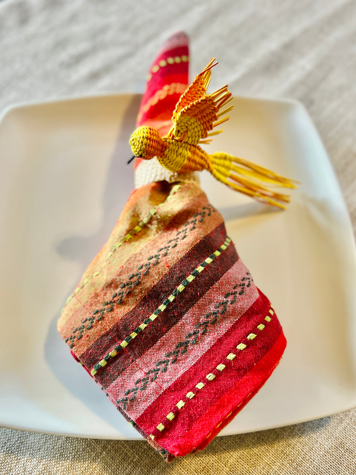 Decorative napkin ring with bird design on a white plate