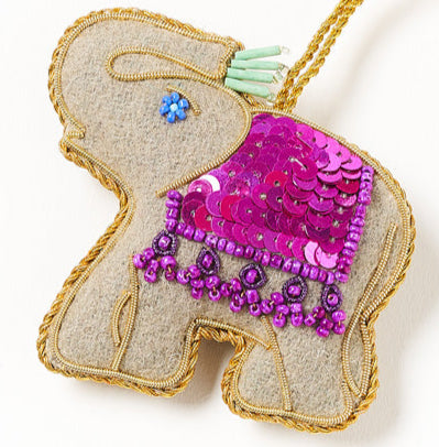 Decorative elephant ornament with sequins and beads on a white background