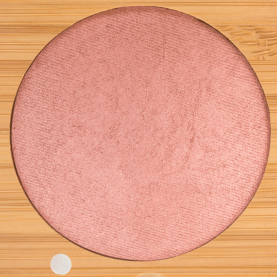 Round pink makeup blush on a wooden background
