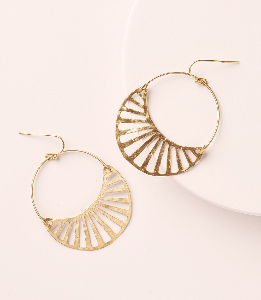 Gold hoop earrings with a geometric design on a light background