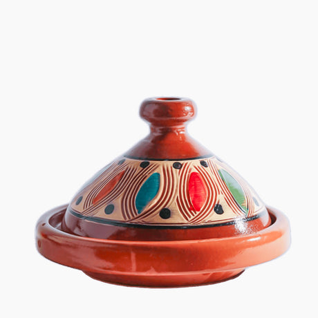Ceramic tagine with colorful patterns on a white background