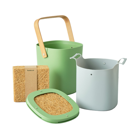 Green and gray buckets with a wooden handle, a brown sponge, and a green lid on a light gray surface.