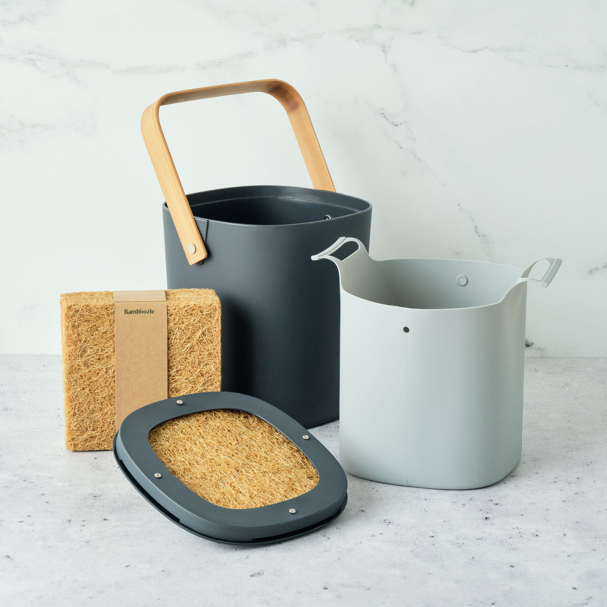 Three containers with a sponge on a light gray surface