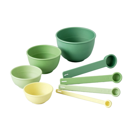 Set of green and yellow measuring cups and bowls on a white background