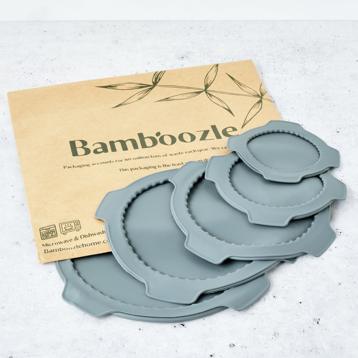 Set of blue silicone lids on a white surface with a 'Bamboozle' branded paper in the background.