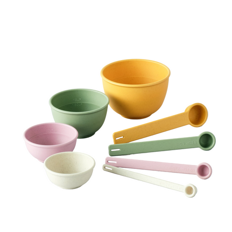 Set of colorful bowls and measuring spoons on a white background