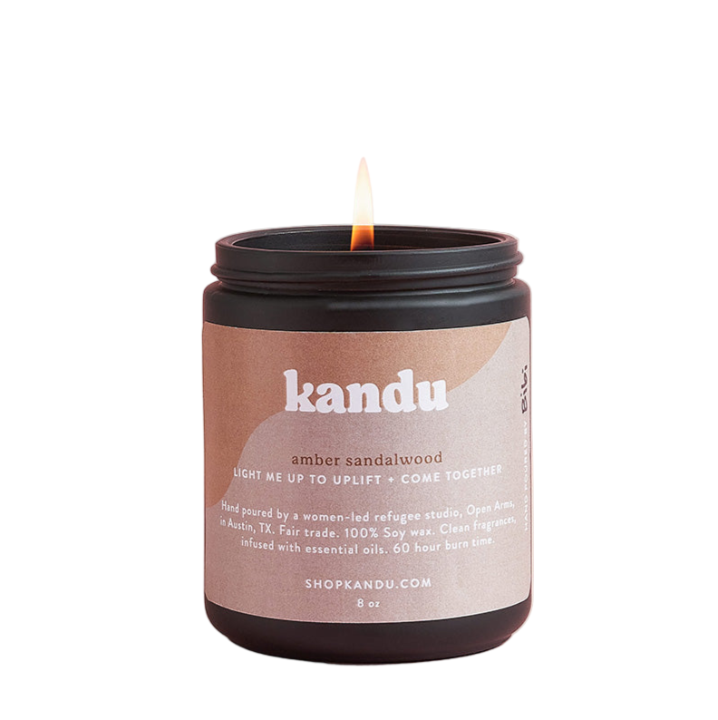 Kandu candle with a visible flame on a white background