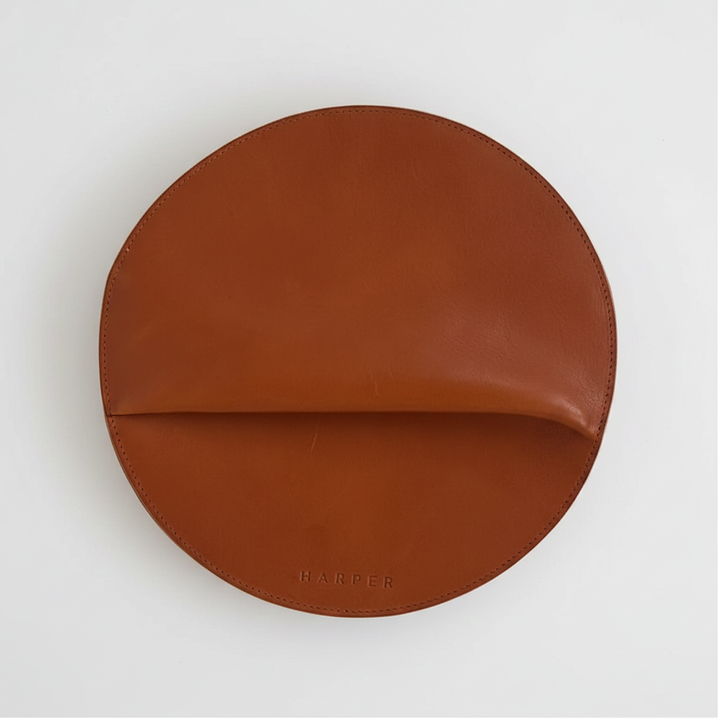 Brown leather round object on a light gray background