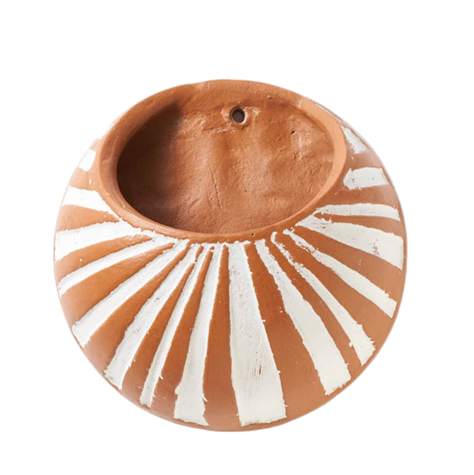 Terracotta hanging planter with sunburst design on a white background
