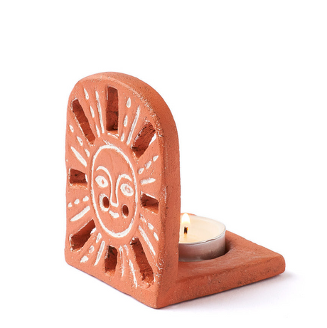 Terracotta candle holder with sun design on a white background