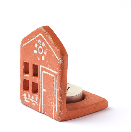 Terracotta house-shaped candle holder with a white door on a white background