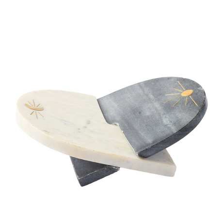 Two marble cutting boards with sun designs on a white background