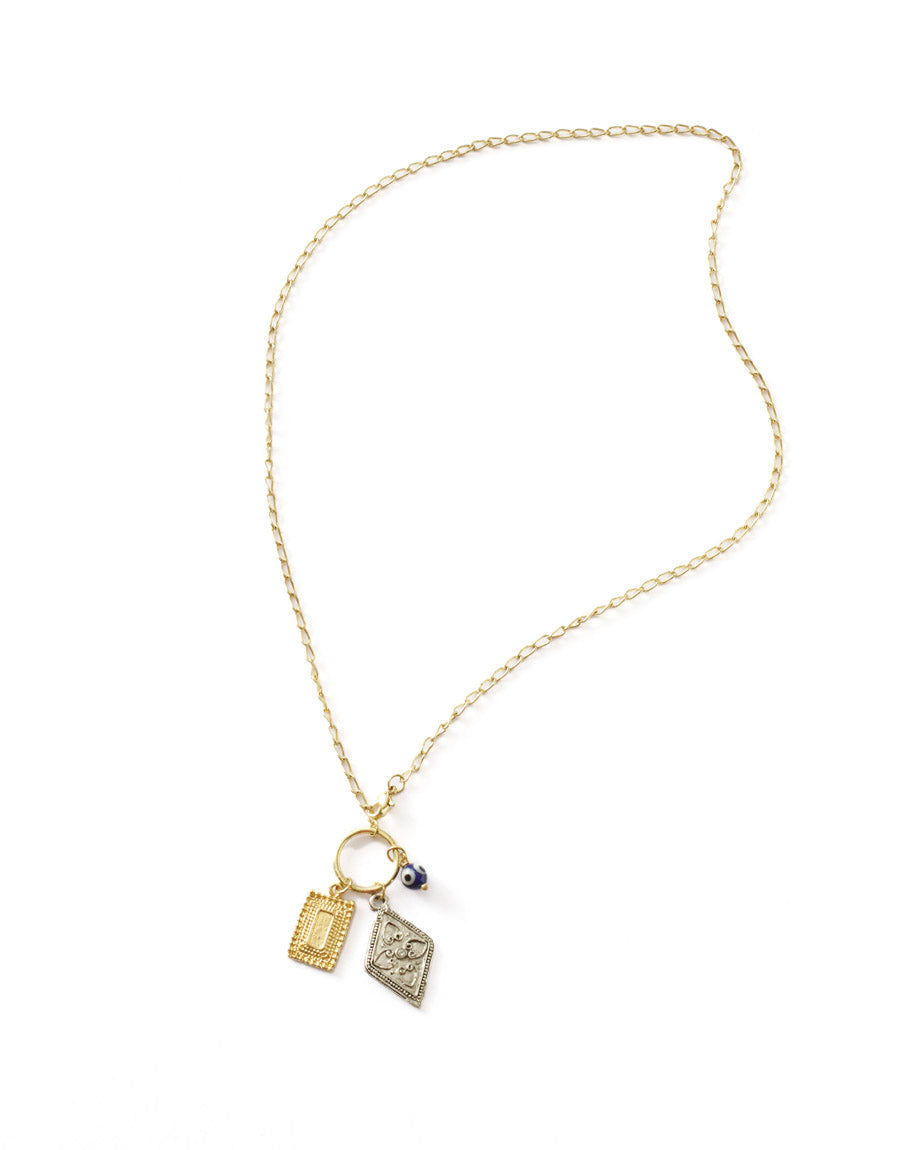Gold necklace with two charms on a white background