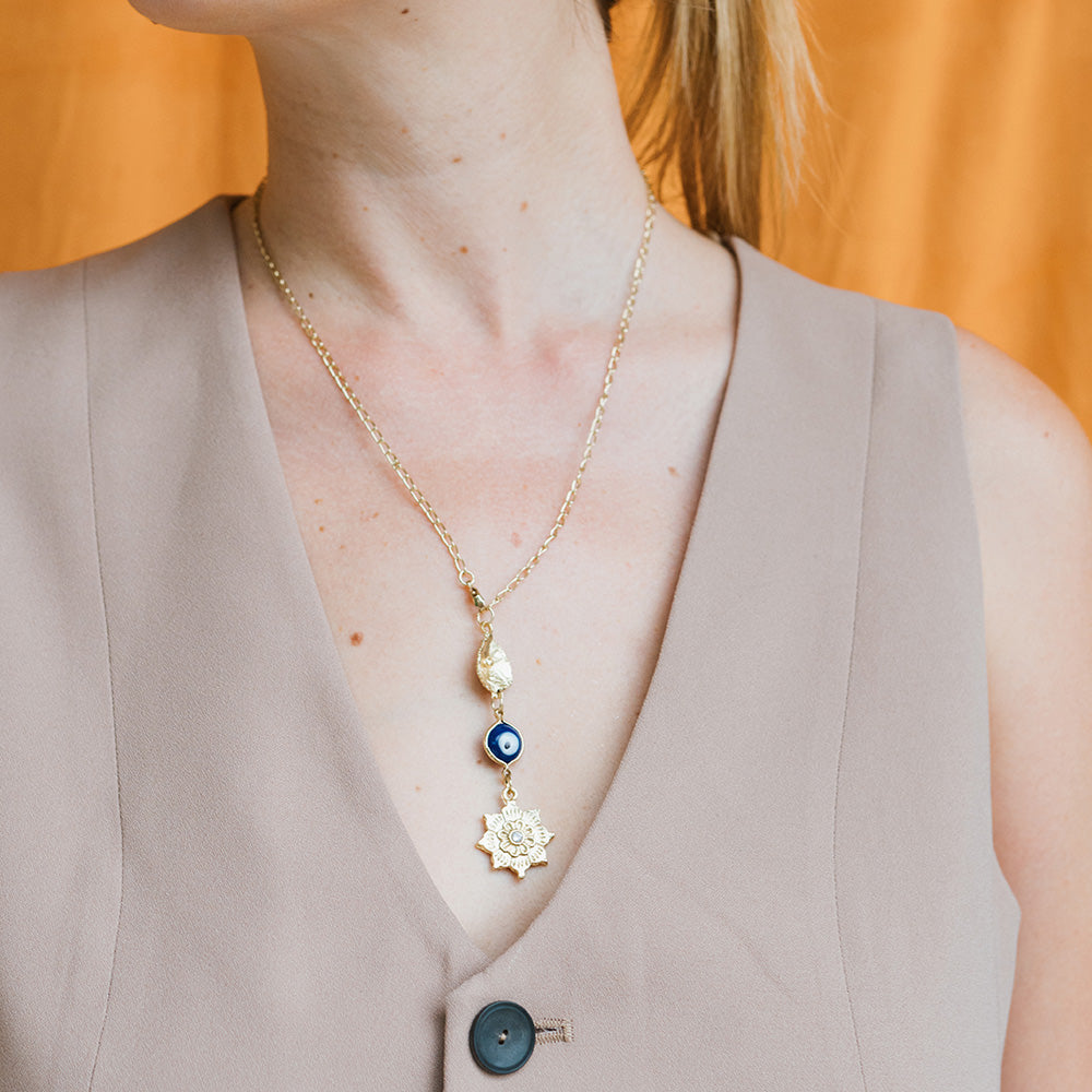 Necklace with floral pendant worn by a person against an orange background