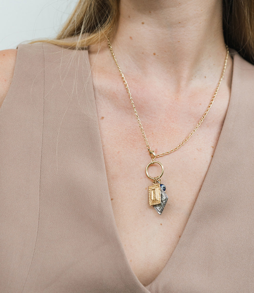 Necklace with a pendant worn by a person against a neutral background