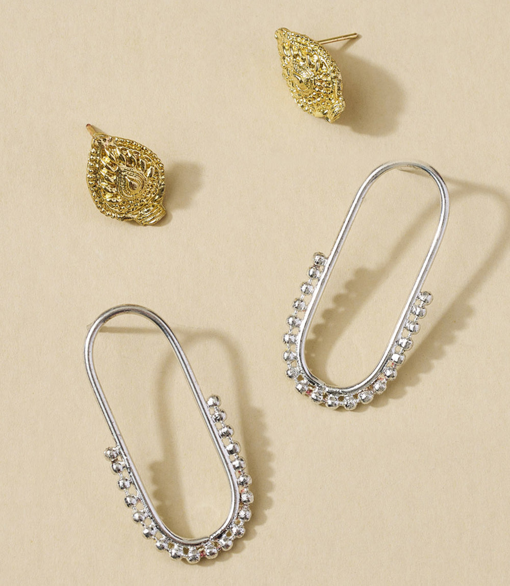 Pair of silver hoop earrings with beaded detailing on a beige background