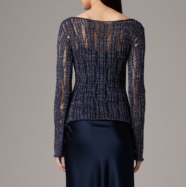 Navy blue textured sweater worn by a person on a gray background