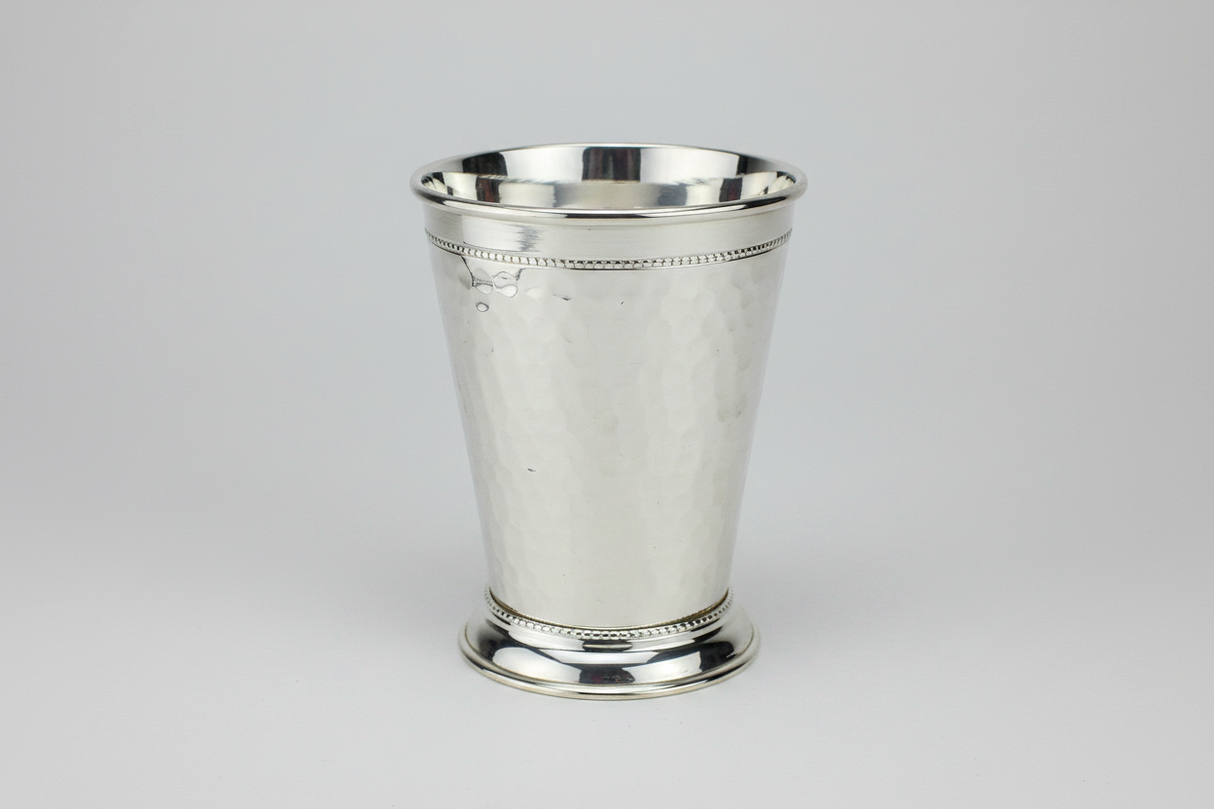 Silver mint julep cup on a light gray background