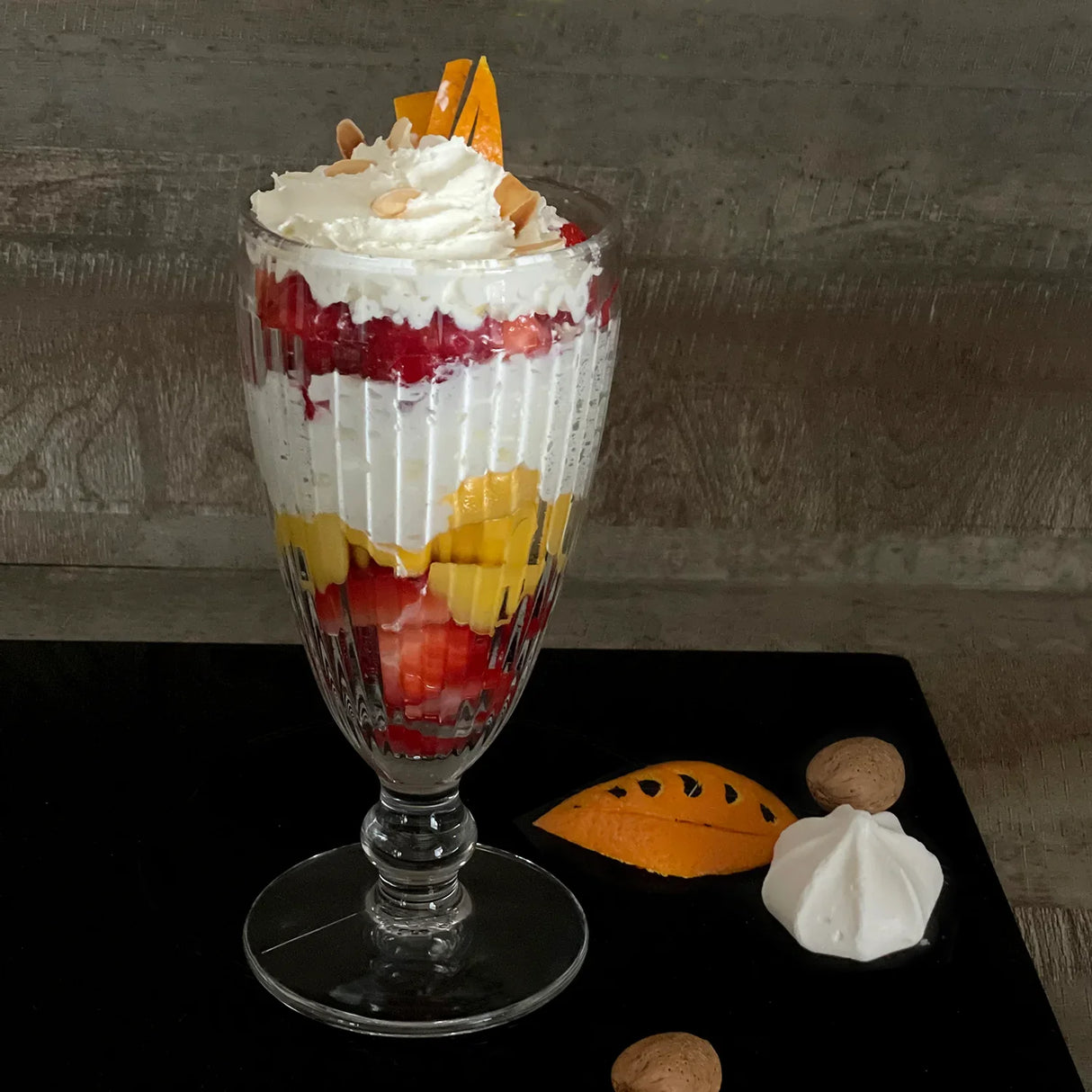 The La Rochere Antillaise Ice Cream Cup offers an elegant presentation for a layered yogurt parfait topped with whipped cream, sliced almonds, and orange zest.
