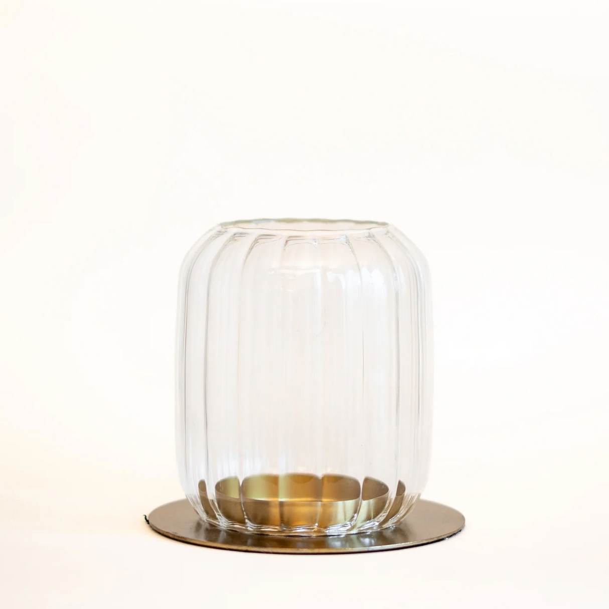 Clear glass dome with brass base on a white background