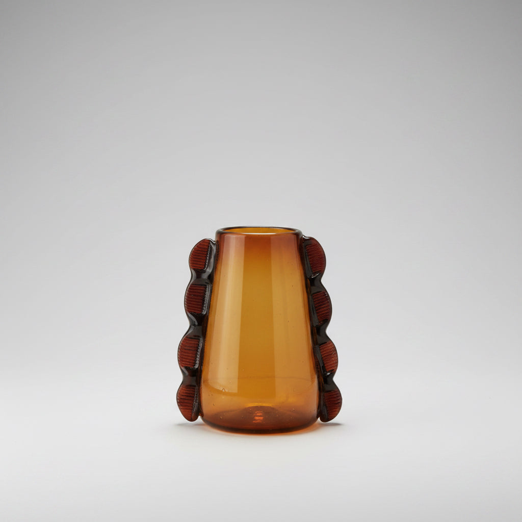 Amber glass vase with decorative brown accents on a beige background