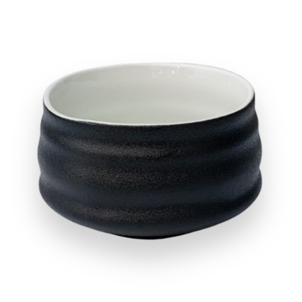 Black and white ceramic matcha bowl with a textured surface on a plain background, reminiscent of Minoyaki pottery.