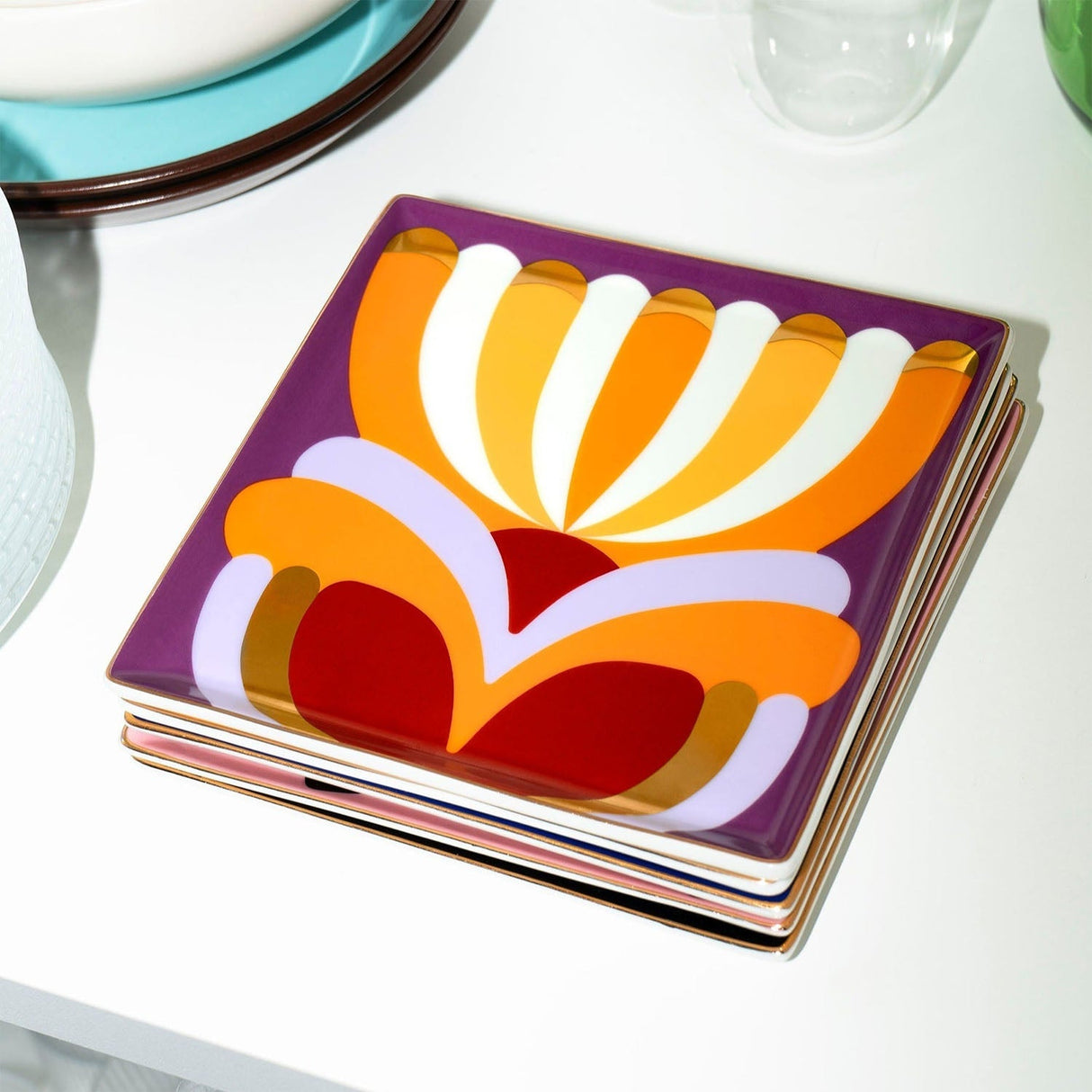 Stack of colorful trays with abstract design on a white surface