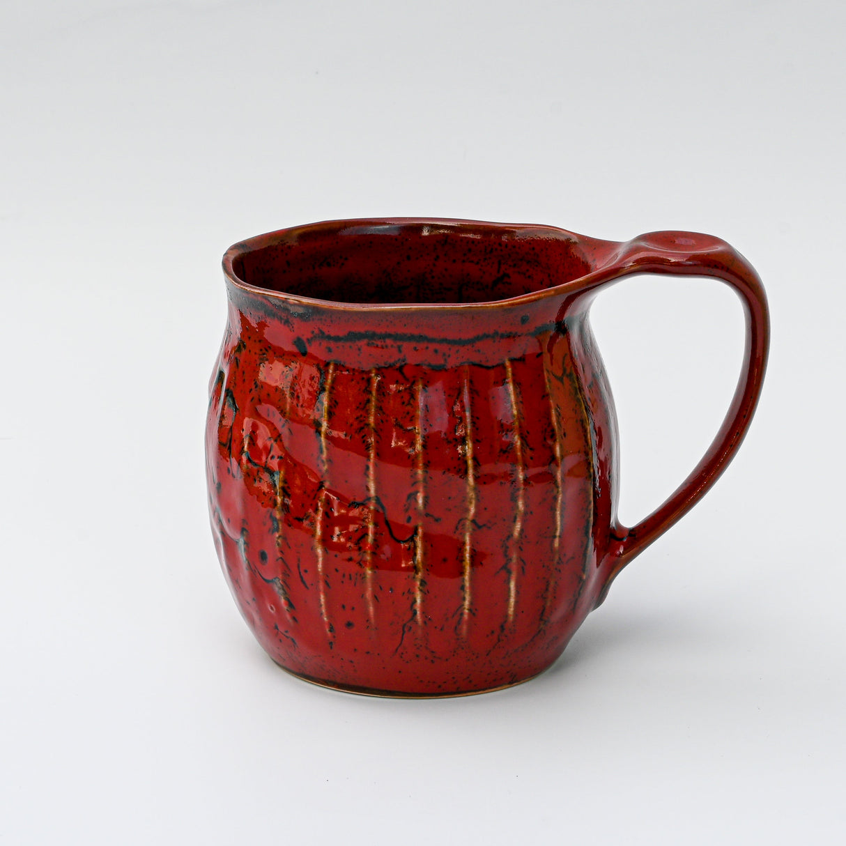 The Handmade Big Red Ceramic Tea or Coffee Mug from Japan features a textured surface and curved handle, showcasing exquisite Japanese craftsmanship against a plain white background.