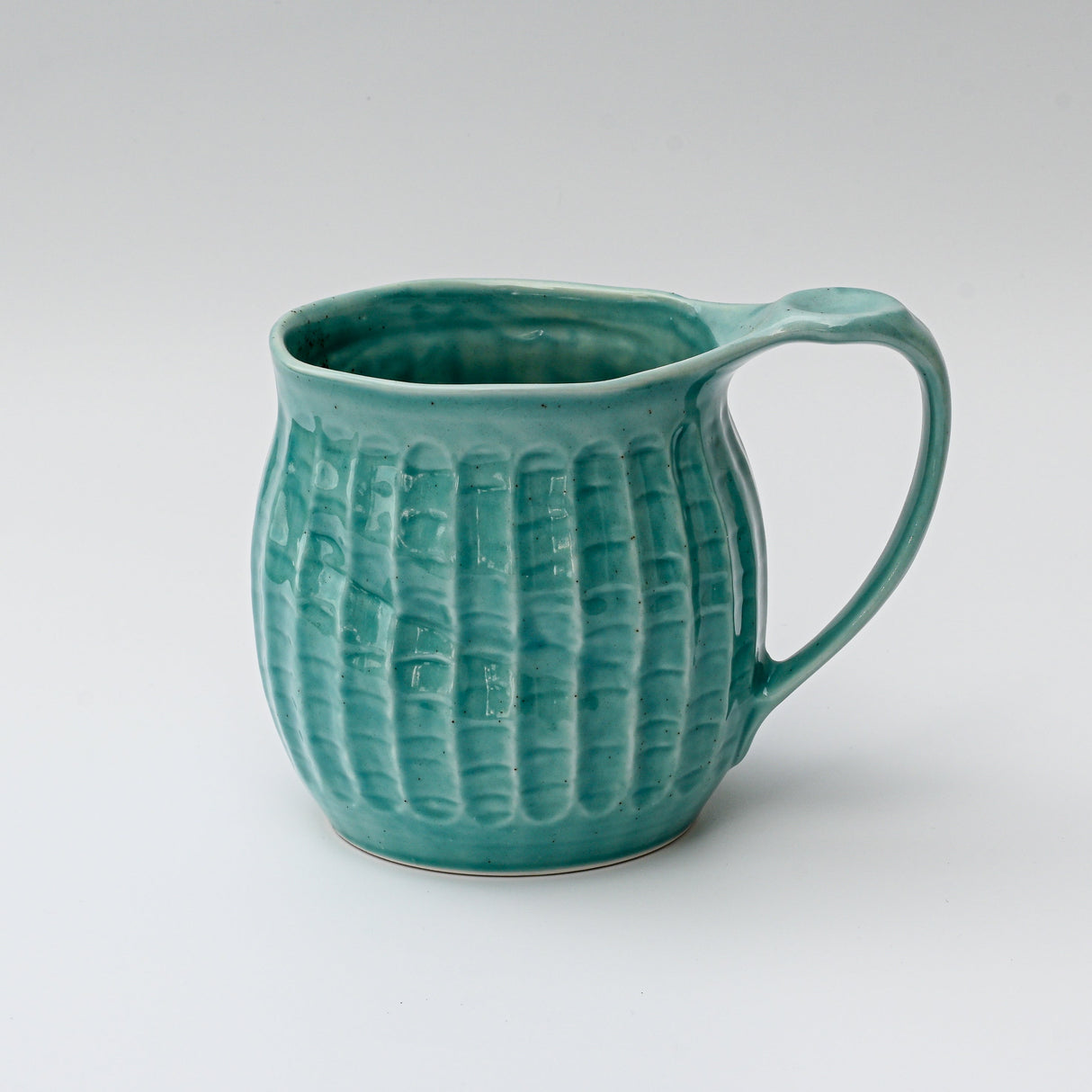 A Handmade Big Blue Ceramic Tea or Coffee Mug from Japan with a handle, showcasing exquisite craftsmanship, rests against a plain white background.