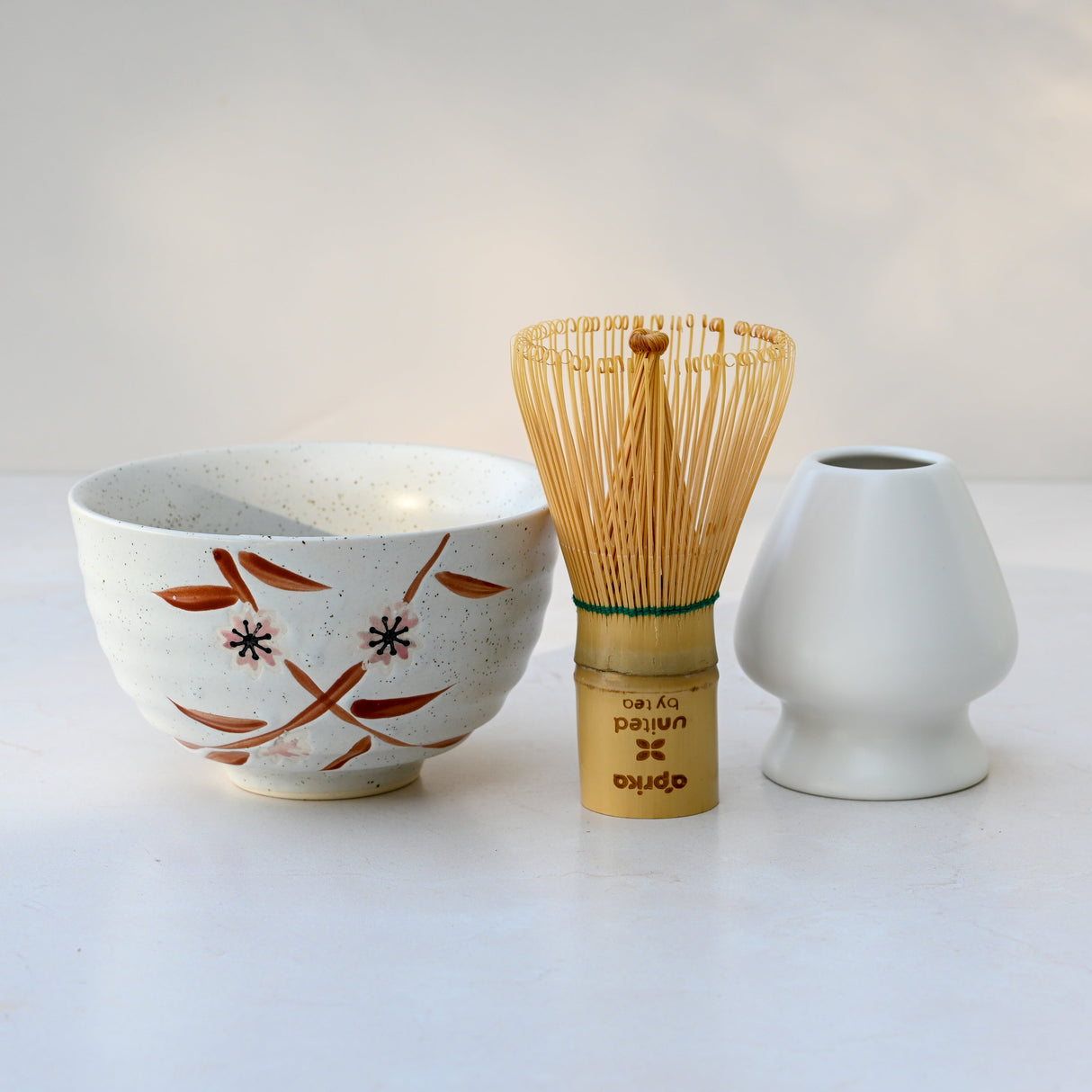 The Bamboo Matcha Bowl, Bamboo Matcha Whisk, and Whisk Holder Set rest on a light surface, showcasing a minimalist and elegant design ideal for any matcha tea set.