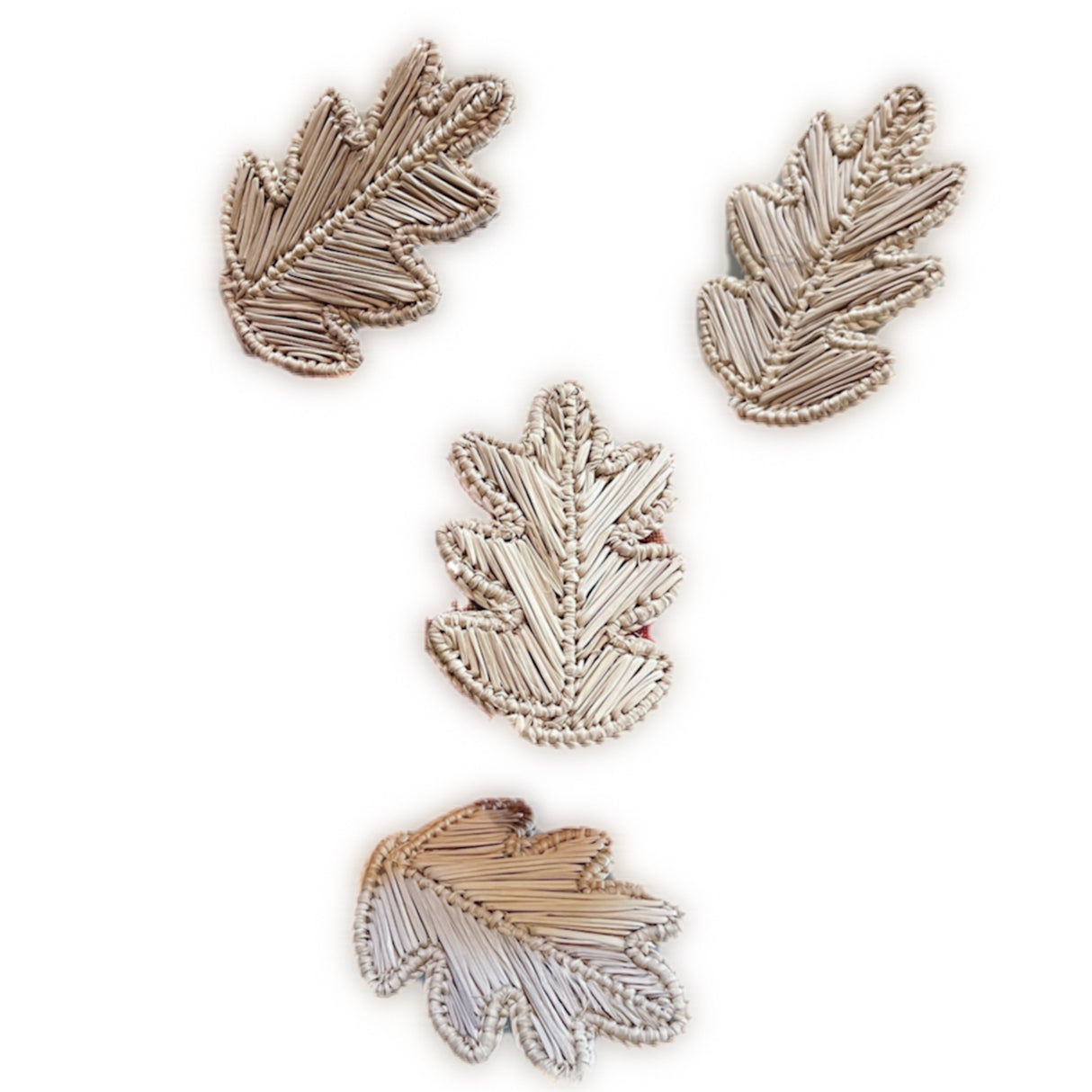 Set of four leaf-shaped napkin rings on a white background
