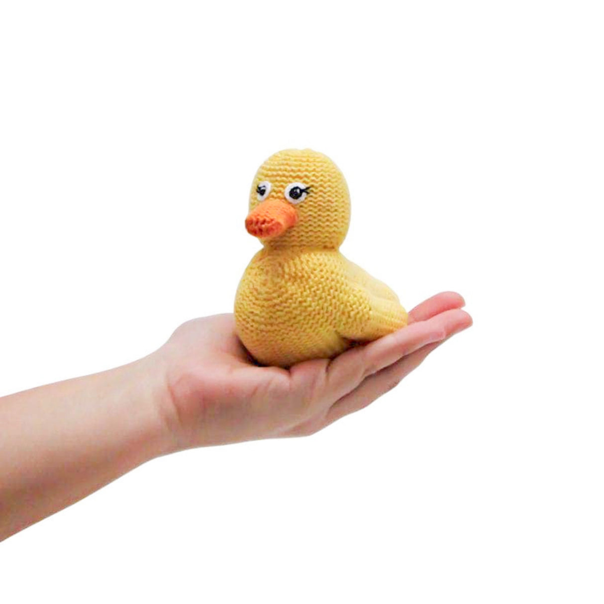 Hand holding a small yellow knitted duck toy against a white background