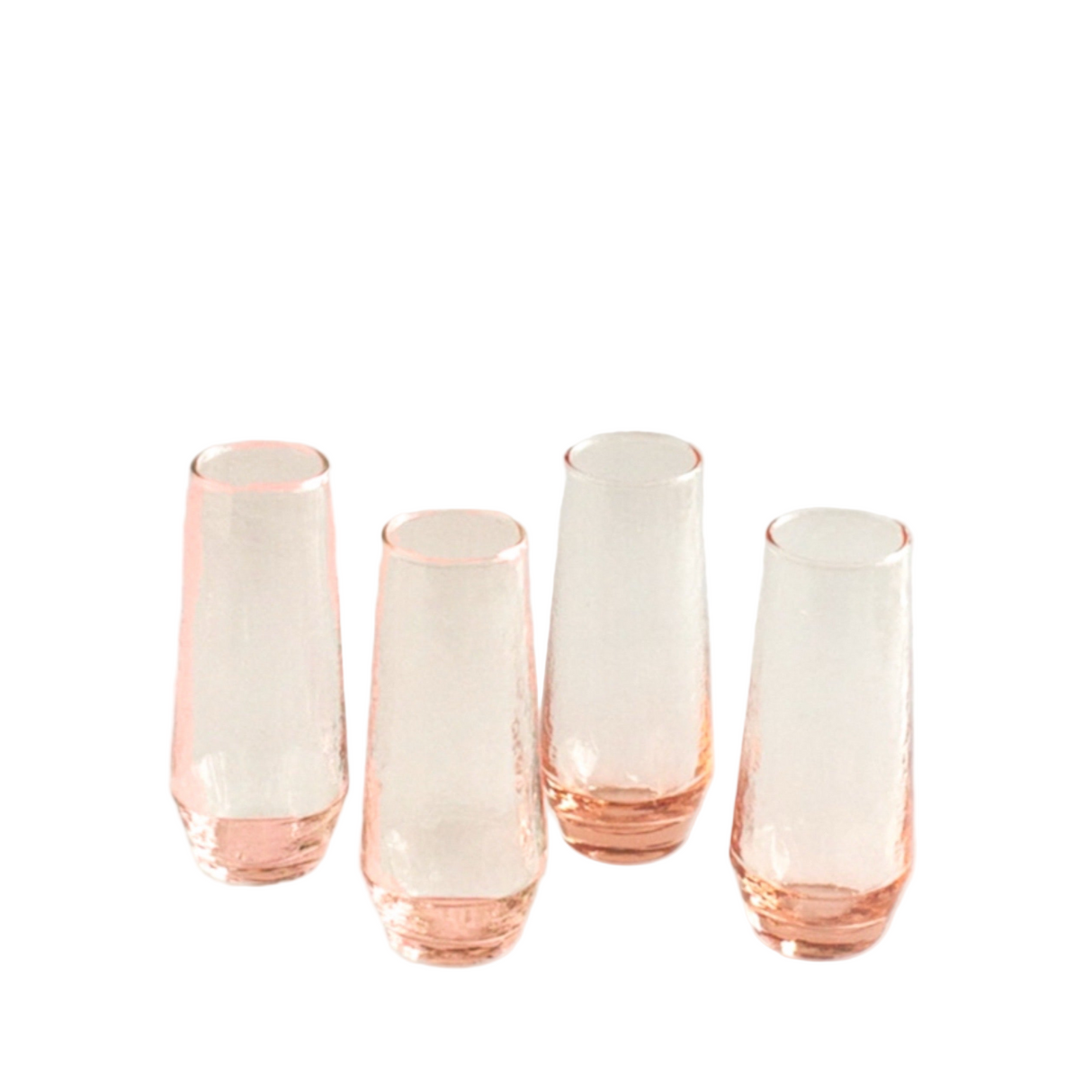 Set of four rose gold fluted glasses on a light gray background