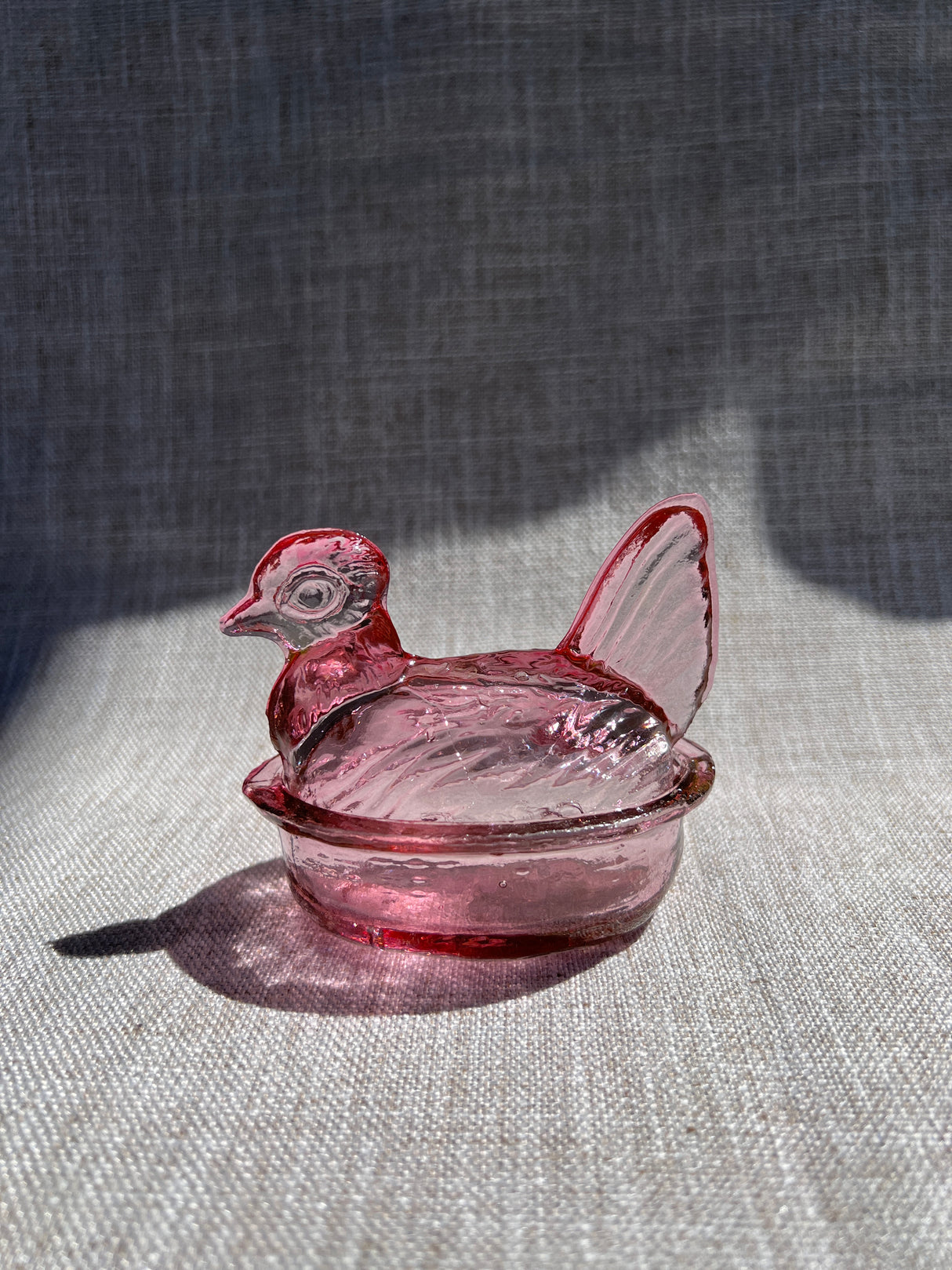Pink glass object on a textured gray surface
