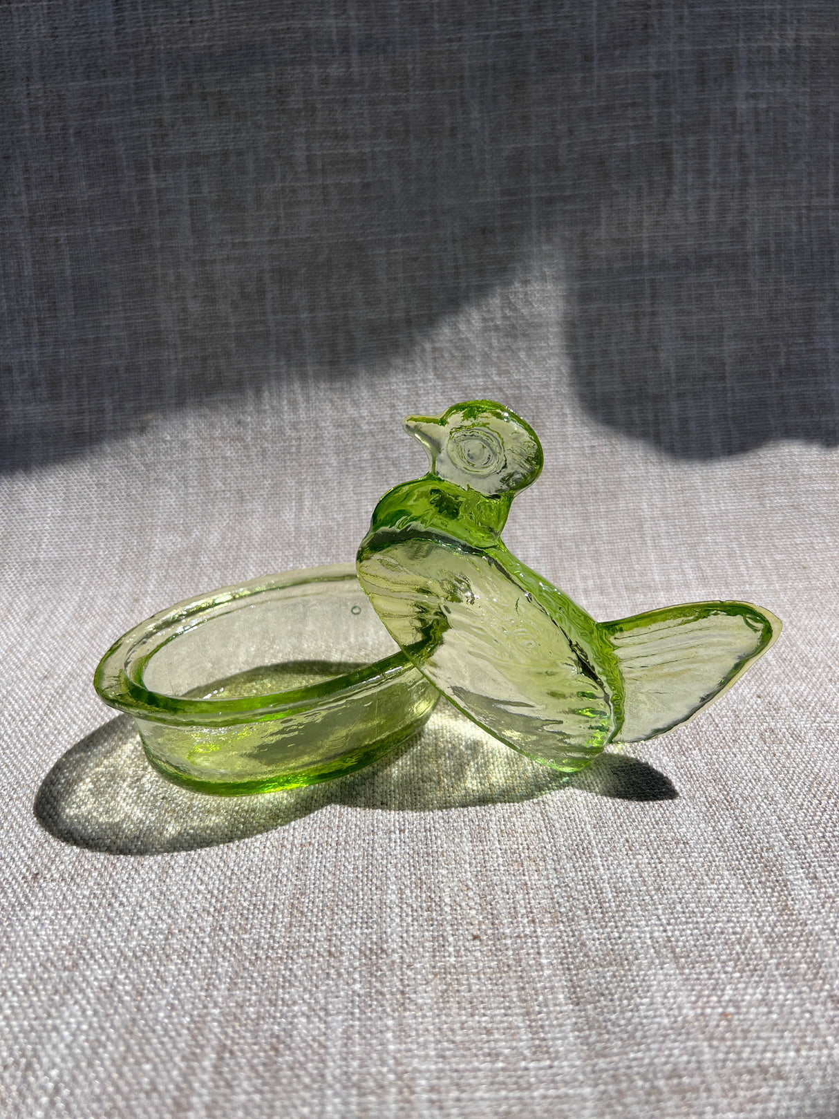 Green glass hen on a gray background