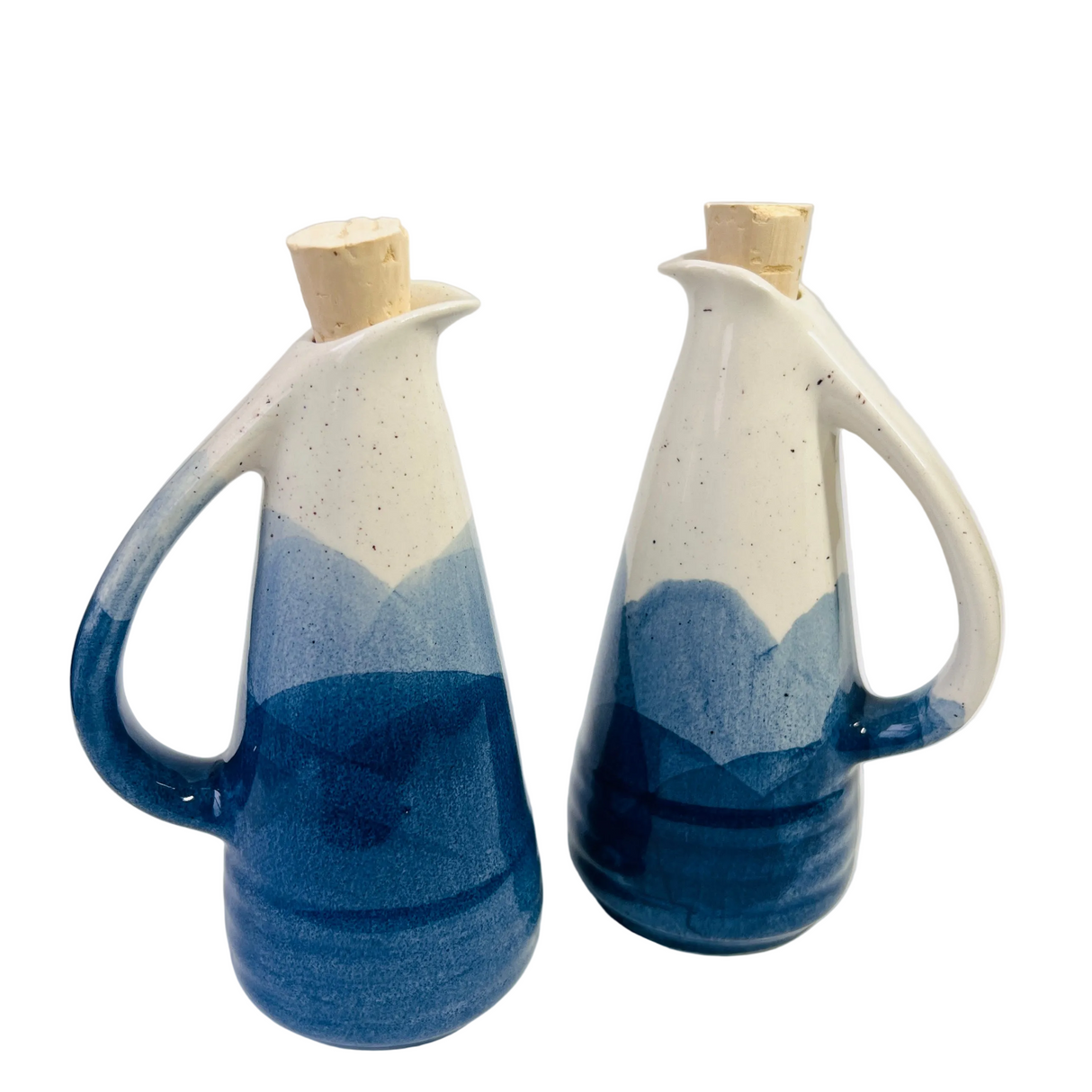 Two ceramic oil and vinegar bottles with blue and white design on a white background