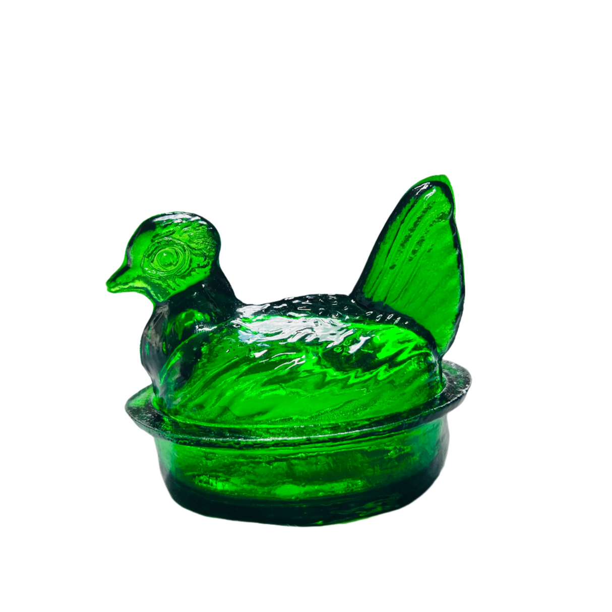 A hand-blown emerald green glass nesting hen with a lid, on a white background.