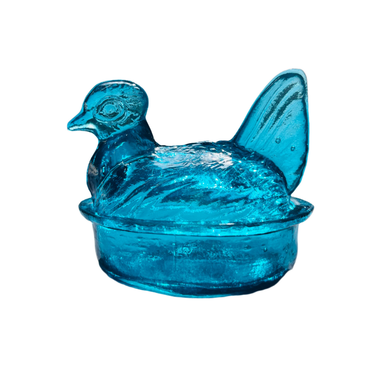 A hand blown glass nesting hen bowl and lid in turquoise color, translucent with visible bubble-like textures, on a white background.