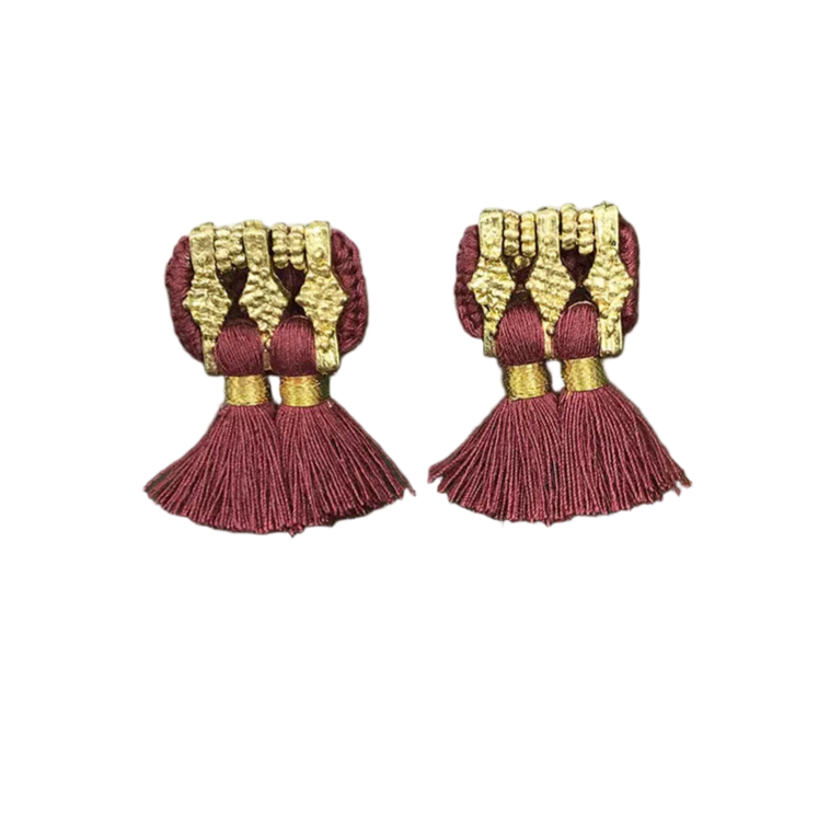 Pair of red and gold tassel earrings on a white background