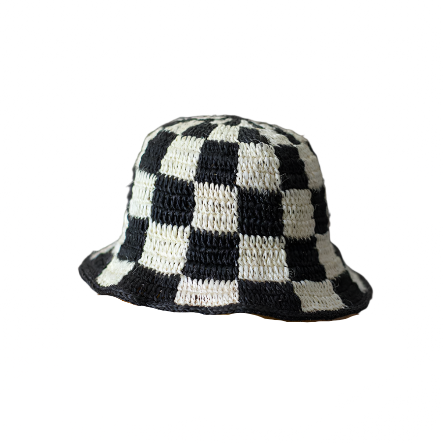 Black and white checkered bucket hat on a wooden block with a white background
