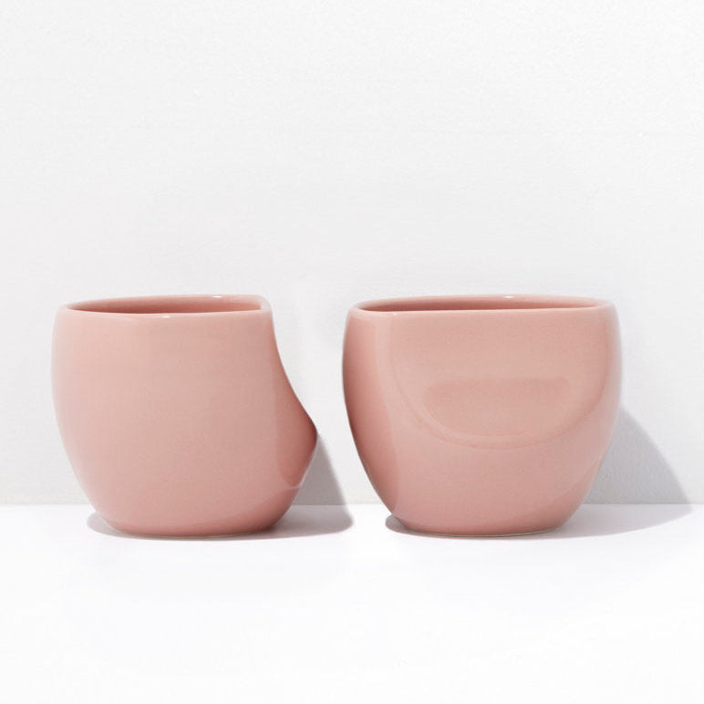 Two pink ceramic cups on a white background