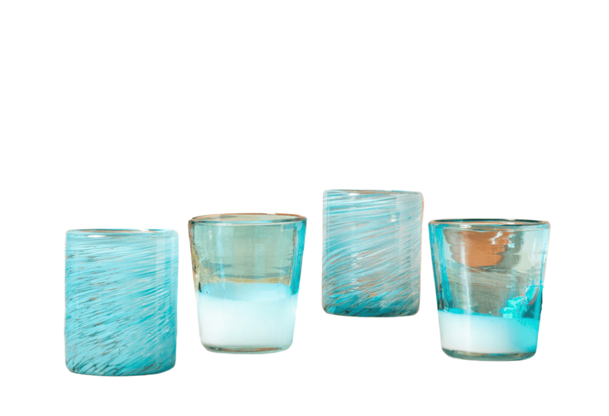 Set of four turquoise glass votive holders on a white background