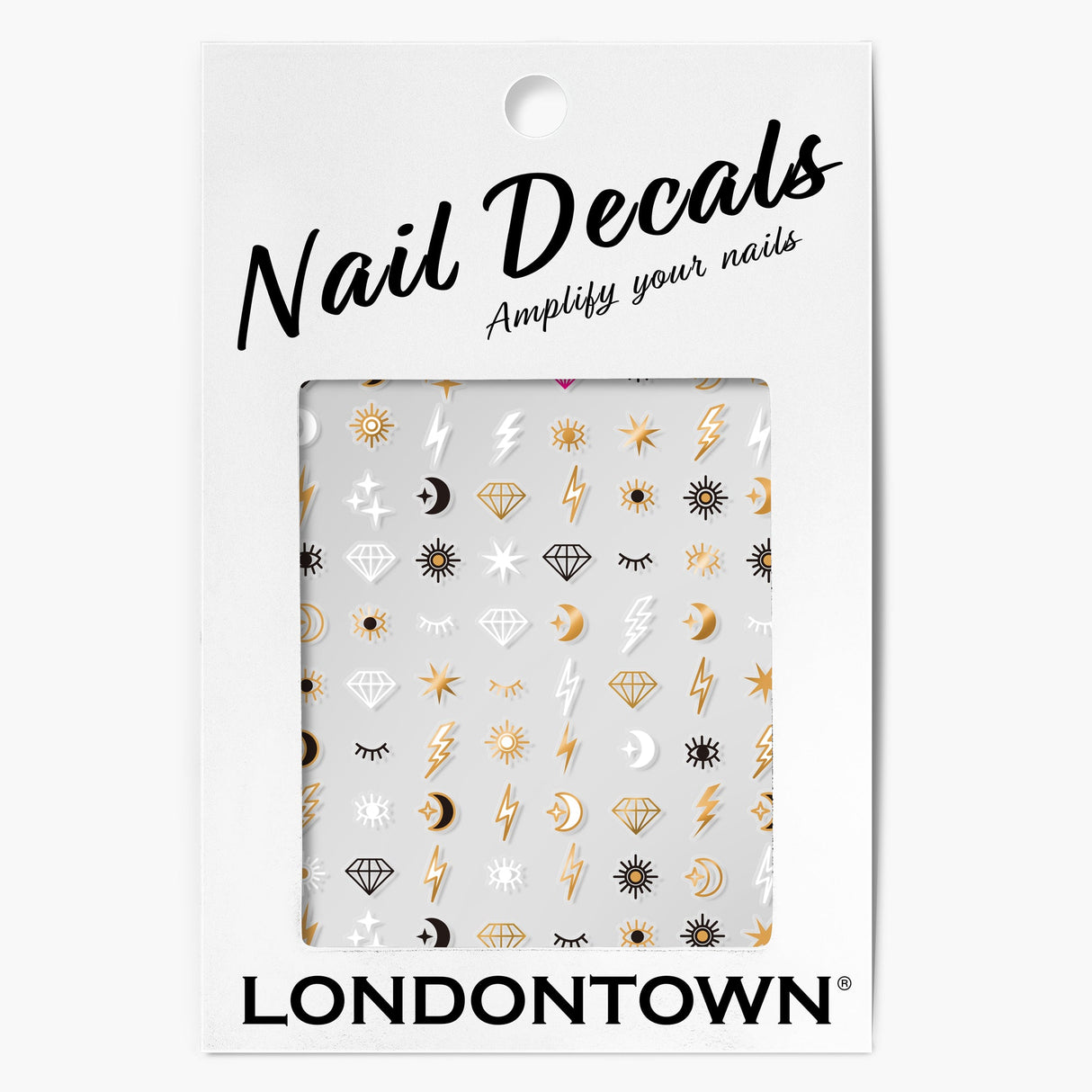 A package of LONDONTOWN Nail Decals - Cosmic featuring various designs like sun, moon, lightning bolts, diamonds, stars, and eyes in gold and black on a white background. The text says "Nail Decals - Amplify your nails with easy nail art.