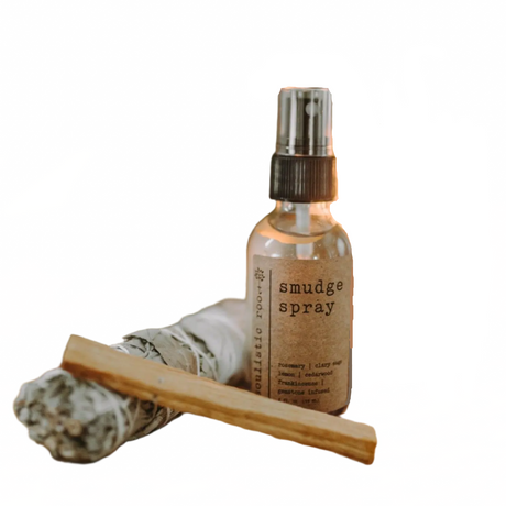 Smudge spray bottle, sage smudging stick, and palo Santo on a white background