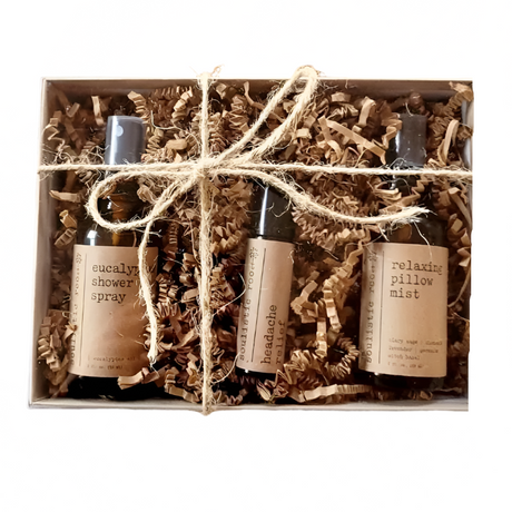 Set of three small bottles with labels in a box wrapped with string on a white background