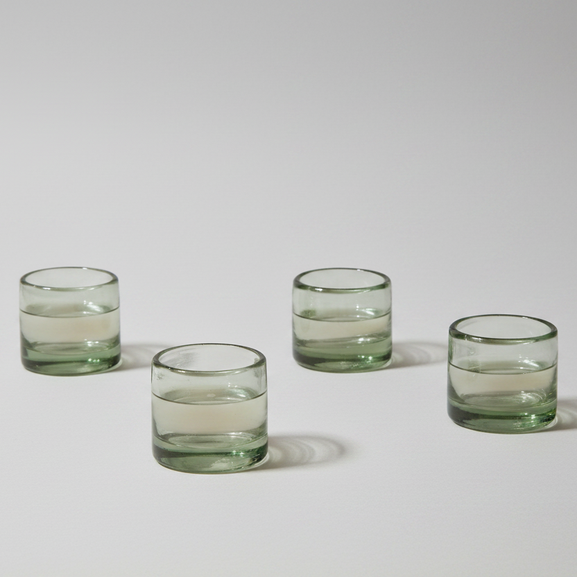 Four glass tumblers on a light gray background