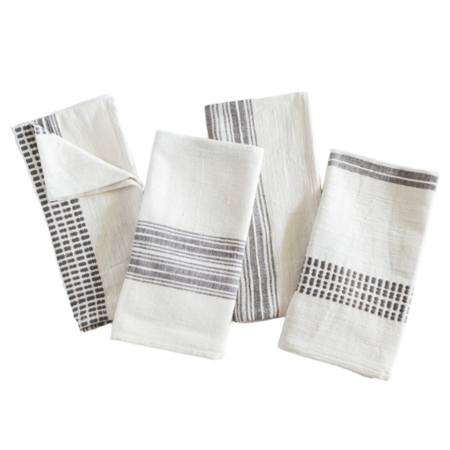 Set of four folded cloth napkins with black patterned borders on a white background