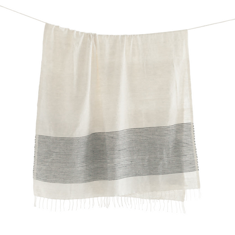 Beige towel with a black horizontal stripe and white fringe on a white background