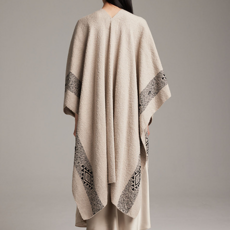 Beige poncho with black geometric patterns on a gray background
